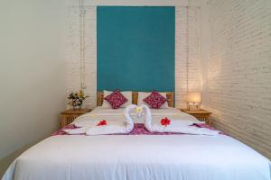 two white swans towels are sitting on a bed at EUFORIA Guest House in Canggu