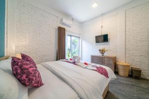 a bedroom with a bed with two stuffed animals on it at EUFORIA Guest House in Canggu