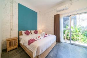 a bedroom with a large bed and a large window at EUFORIA Guest House in Canggu