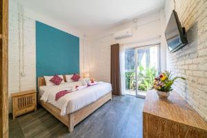 a bedroom with a large bed and a large window at EUFORIA Guest House in Canggu