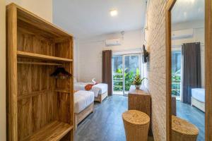 a bedroom with two beds and a large wooden closet at EUFORIA Guest House in Canggu