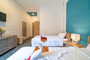 a hotel room with two beds and a couch at EUFORIA Guest House in Canggu