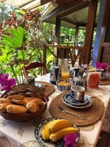 una mesa con platos de pan y plátanos. en Pousada Vitorino en Angra dos Reis