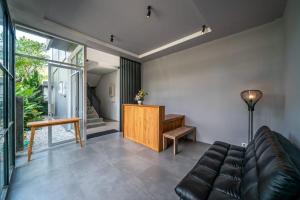 a living room with a leather couch and a desk at EUFORIA Guest House in Canggu