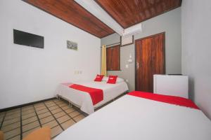 a bedroom with two beds and a tv at OYO Pousada Do Coco, Porto Seguro in Porto Seguro