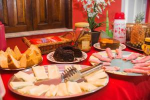 una mesa cubierta con placas de queso y otros alimentos en OYO Pousada Do Coco, Porto Seguro, en Porto Seguro