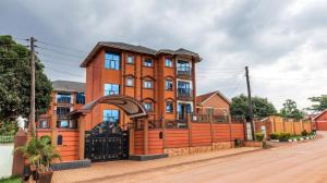 a large orange building with a black gate at Great deal apartment - Blue Pearl in Kampala