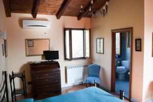 a bedroom with a bed and a television and a toilet at Il Giardino delle Esperidi in Fosdinovo