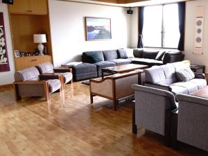 una sala de estar con sofás y mesas. en Refre Hotel en Myoko