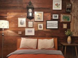 um quarto com uma parede de madeira, uma cama e um relógio. em ทุ่งยั้งเฮ้าส์ em Uttaradit