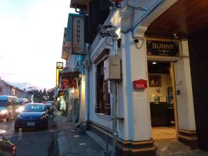 a street with a car parked in front of a building at Phuket Sunny Hostel in Phuket Town