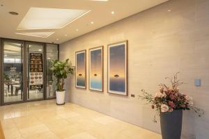 a lobby with two large vases with flowers in it at Golden Daisy Hotel in Seogwipo