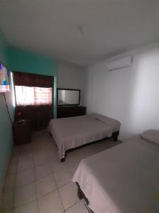 um quarto com duas camas e uma televisão em Casa "Linda Vista" em Cuatrociénegas de Carranza