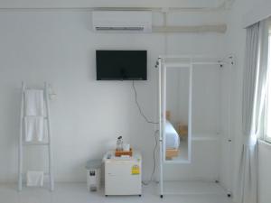 Dieses weiße Zimmer verfügt über einen TV an der Wand. in der Unterkunft PATRA Agaligotel in Fang