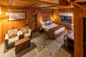 a bedroom with a bed and a couch in a room at The Baagh Ananta Elite Ranthambore in Khilchipur