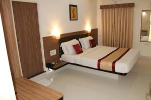 Habitación de hotel con cama y espejo en Hotel Grand Bee Bangalore, en Bangalore