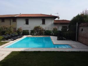 a swimming pool in front of a house at B&B Al Vec Licinsi' in Moniga