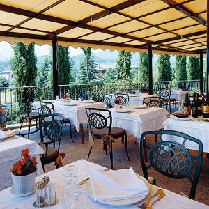 - un restaurant avec des tables et des chaises blanches offrant une vue dans l'établissement Hotel Ristorante La Lanterna, à Castelnuovo di Garfagnana