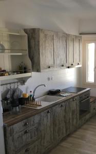 una cucina con armadi in legno e lavandino di Villa Tranquilita a Kastraki