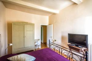 a bedroom with a bed and a flat screen tv at Lapieve in Scalenghe