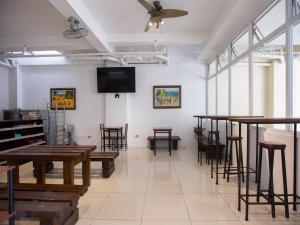a room with tables and chairs and a flat screen tv at Sulit Hotel Manila in Manila