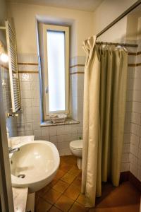 uma casa de banho com um lavatório, um WC e um chuveiro em Lapieve em Scalenghe