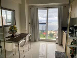 a kitchen with a table and a large window at Elize Wind Residences in Tagaytay