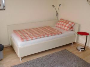 ein weißes Sofa mit zwei Kissen auf einem Zimmer in der Unterkunft Appartement Ilse Herbert in Würzburg