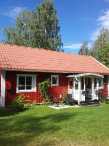 a red cottage with a red roof at Björkslingan in Vimmerby