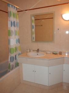 een badkamer met een wastafel en een spiegel bij Casa da Barra in Praia da Barra