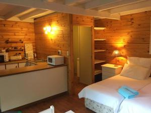 a bedroom with a bed and a kitchen with a microwave at Riversong Farm in Stilbaai