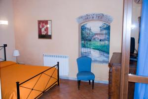 a bedroom with a bed and a blue chair at Il Giardino delle Esperidi in Fosdinovo
