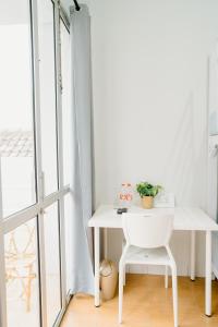 a white table and chair in a room with a window at Ministry Homestay in Yogyakarta