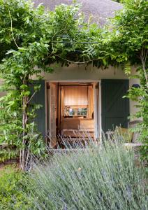 a house with a green door and some plants at La Clé Lodge in Franschhoek