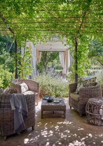 a patio with two chairs and a table and a gazebo at La Clé Lodge in Franschhoek