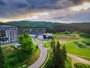 an aerial view of a building with a road and trees at Cosy Loft flat in Silver Mountain of Poiana Brasov in Poiana Brasov