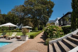 un jardín con piscina y una casa en The Alphen Boutique Hotel & Spa, en Ciudad del Cabo