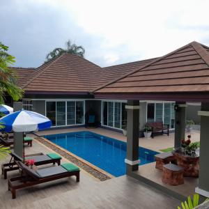 eine Villa mit einem Pool und einem Haus in der Unterkunft Khaolak Yama Resort - SHA Plus in Khao Lak