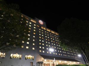a building with a clock on top of it at night at Hotel Nikko Narita in Narita