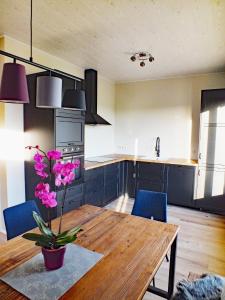 una cocina con una mesa de madera con flores púrpuras. en Skidbakki Guesthouse, 