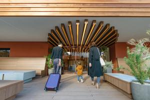 two adults and a child walking through a lobby at The OneFive Terrace Fukuoka in Fukuoka