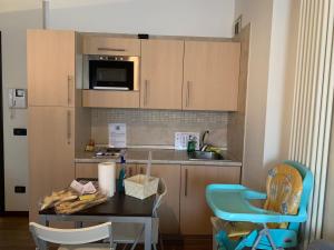 eine Küche mit einem Tisch, Stühlen und einem Waschbecken in der Unterkunft Guest House Delizia Estense in Ferrara
