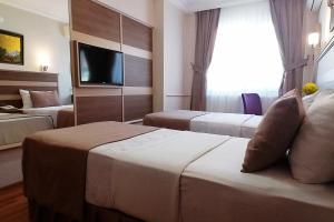 A bed or beds in a room at Sembol Hotel