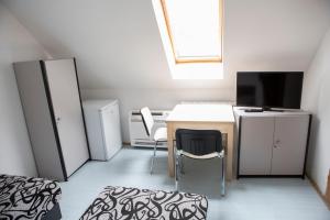 a small room with a desk and a television at Éva Vendégház in Kaposvár