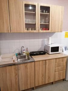 una cocina con fregadero y microondas en una encimera en Brīvdienas, en Alūksne
