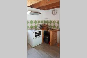 uma cozinha com um fogão branco e um lavatório em Cleuziou Vraz em Lopérec