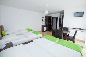 a room with three beds and a table and a desk at Willa Północna II in Karwia