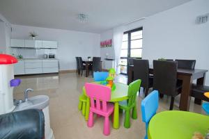 a living room with colorful chairs and a table at Willa Północna II in Karwia