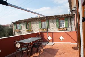 a patio with a table and chairs on a balcony at Il Giardino delle Esperidi in Fosdinovo +21 photos