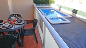 balcone con tavolo e piscina di SAN FERNANDO PALACE III - Beach House a Oliva